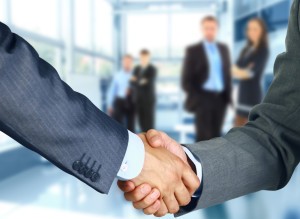 Business associates shaking hands in office
